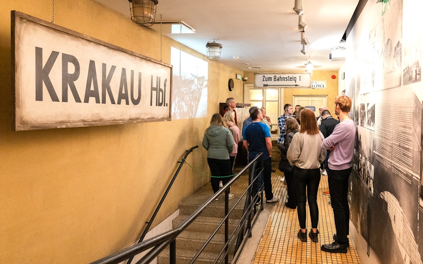 Visitors on a guided tour inside Oskar Schindler's Factory, Krakow, viewing historical exhibits.