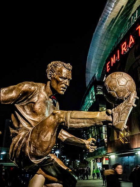 Statue of Dennis Bergkamp performing a kick at Emirates Stadium.