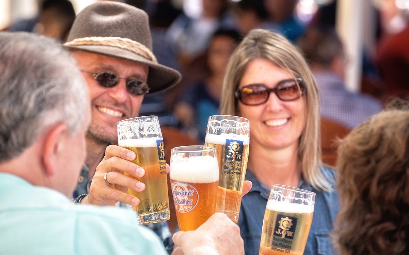 People toasting with beer glasses on a Munich beer tour.