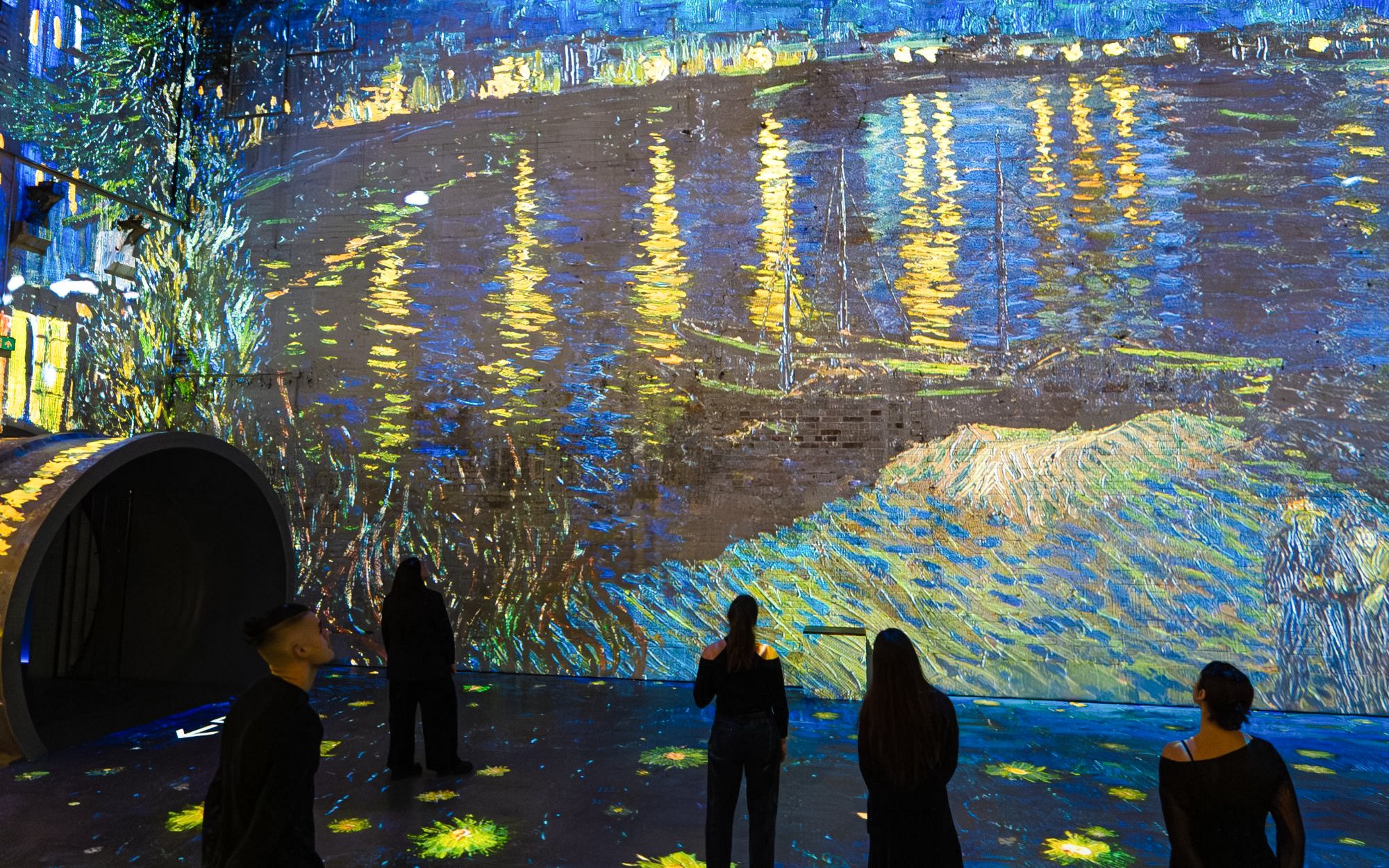 Visitors viewing Van Gogh's "Starry Night Over the Rhône" at Dutch Masters Exhibition, Fabrique des Lumières.