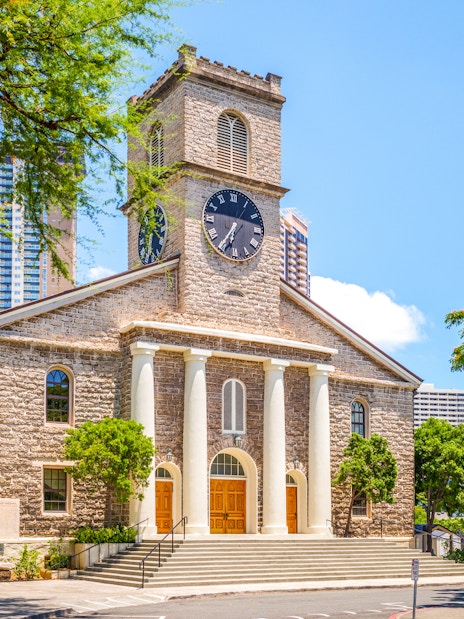 Kawaiahao Church with clock tower and palm trees in Honolulu, Oahu, Hawaii.