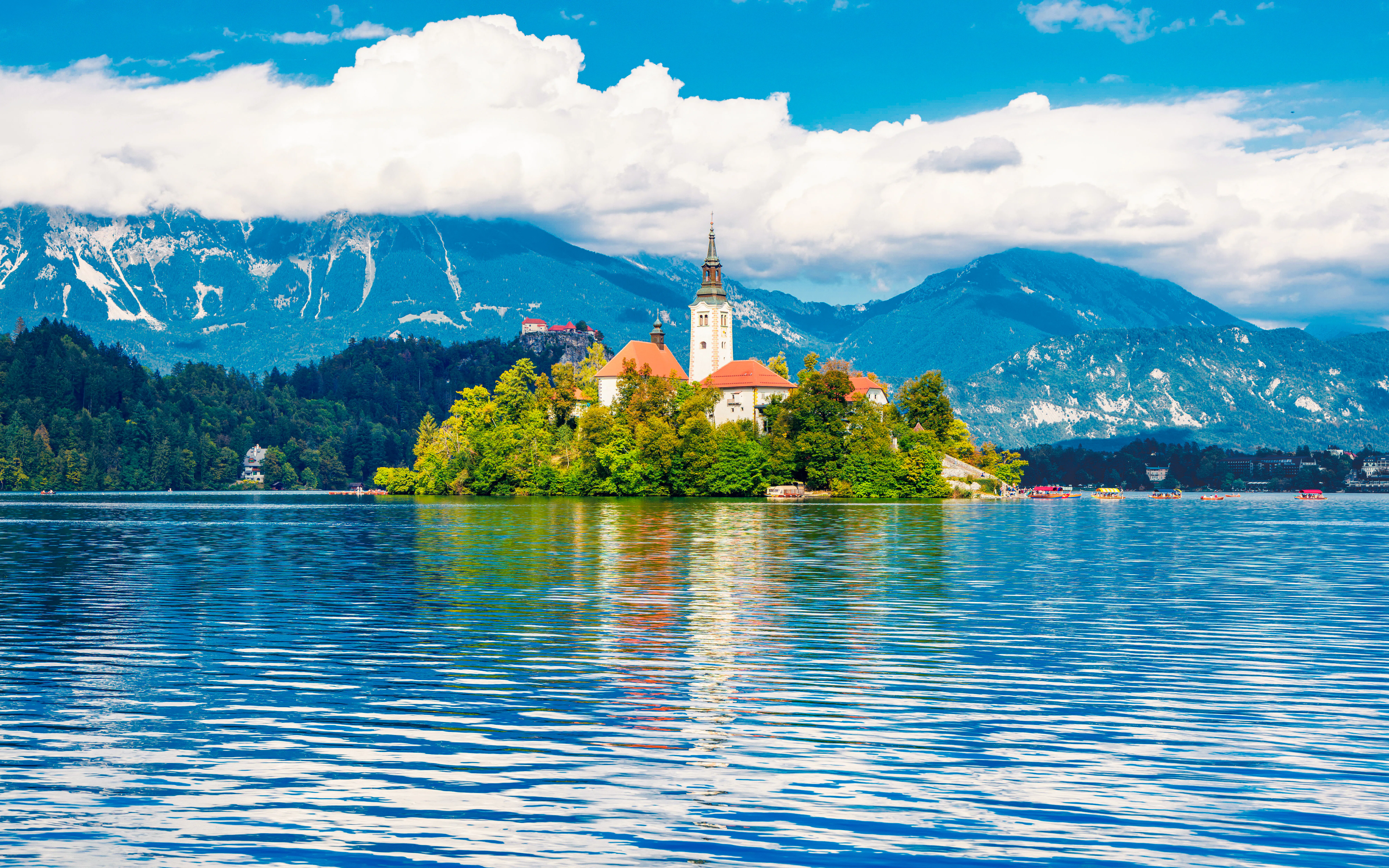 Church on Bled Island with mountains and lake in Slovenia.