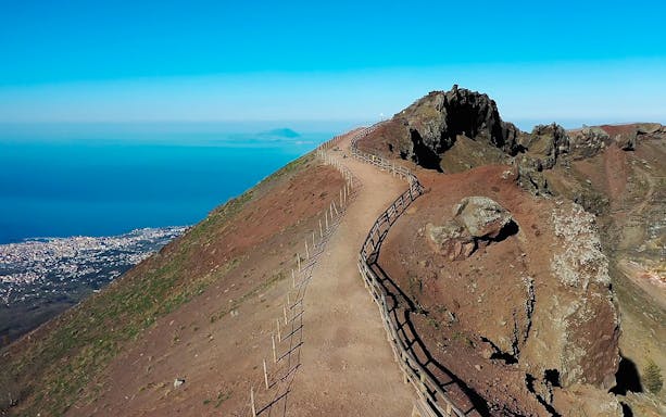 Pathway along Mount Vesuvius with view of Naples and the sea in the background.