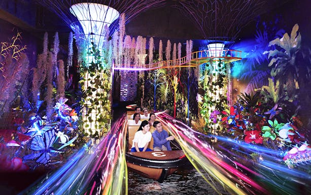 Visitors enjoying a vibrant boat ride with colorful lights and plants at Madame Tussauds Singapore.