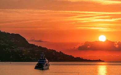 Sunrise over sea with boat near Beaulieu-sur-Mer, France.