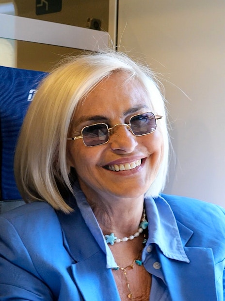 Two women smiling on an Italian train journey.