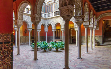 Casa de Salinas courtyard with ornate arches and tiled walls in Seville, Spain.