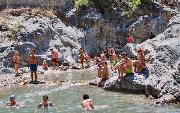 People enjoying a natural pool during the Antalya Jeep Safari tour.