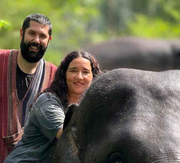 Couple interacting with an elephant during a bathing experience at Phuket Elephant Care Sanctuary.