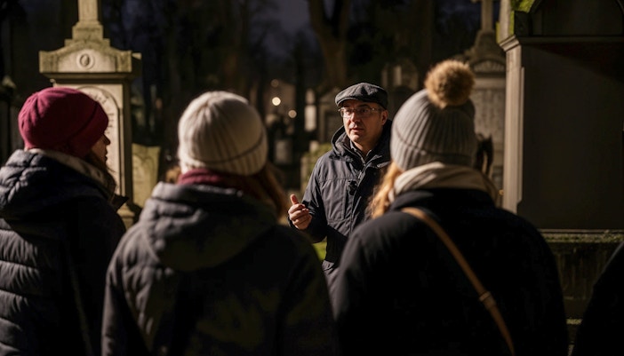 Tour guide leading a haunted cemetery bus tour at night.
