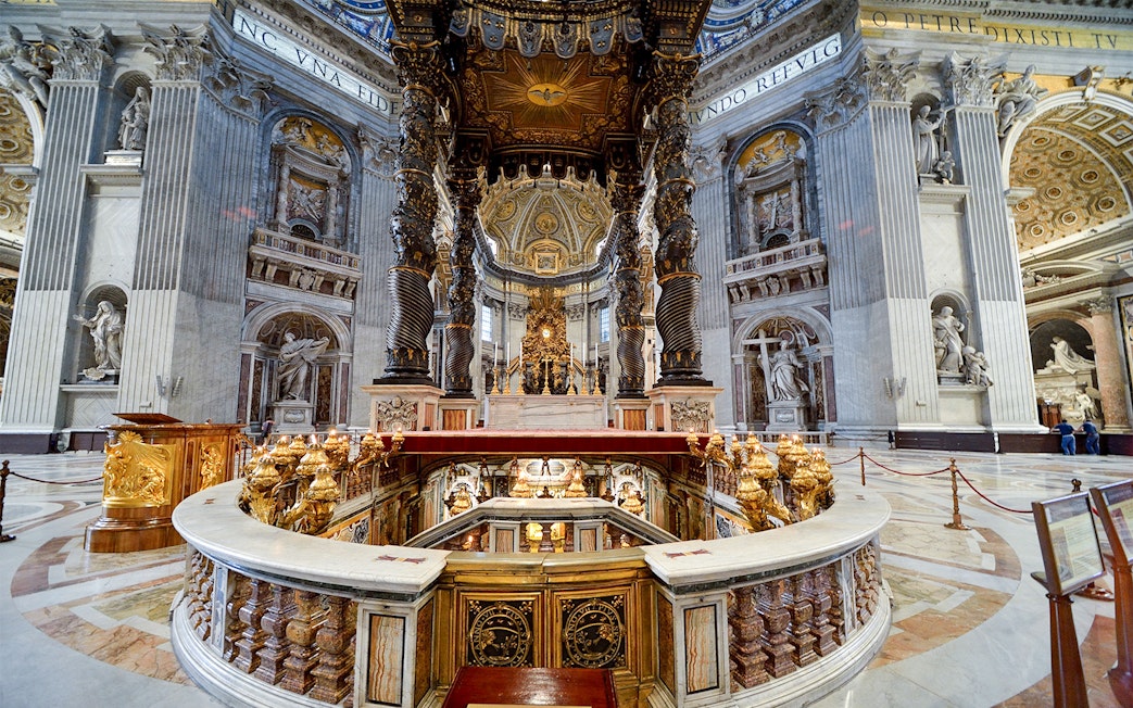 St. Peter's Basilica interior with ornate altar and spiral columns in Vatican City.