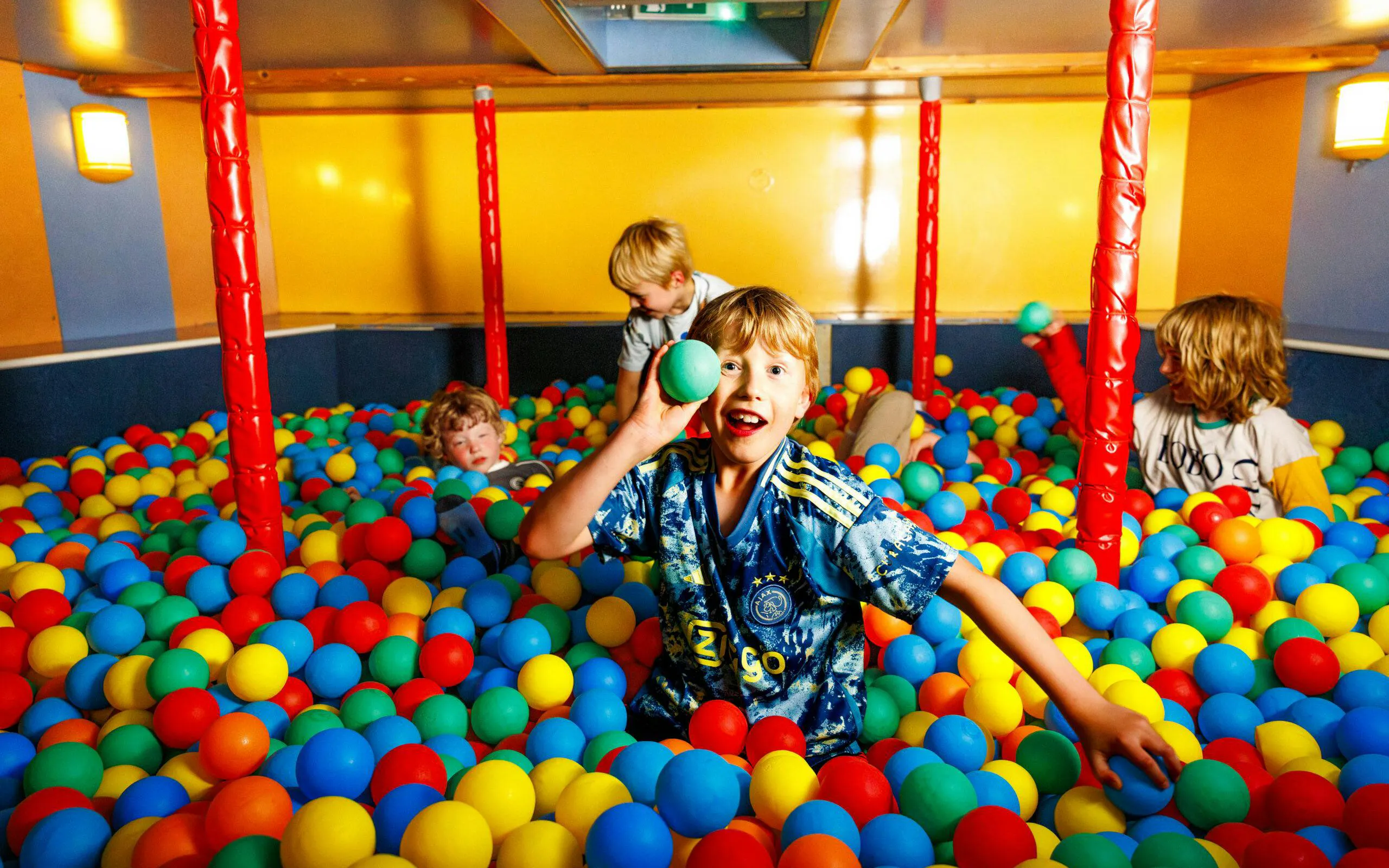 Children playing in a colorful ball pit on the All-You-Can-Eat Dutch Pancake cruise in Amsterdam.