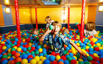 Children playing in a colorful ball pit on the All-You-Can-Eat Dutch Pancake cruise in Amsterdam.