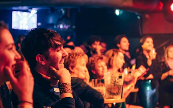 Audience enjoying a lively performance at Madame Arthur cabaret in Paris.