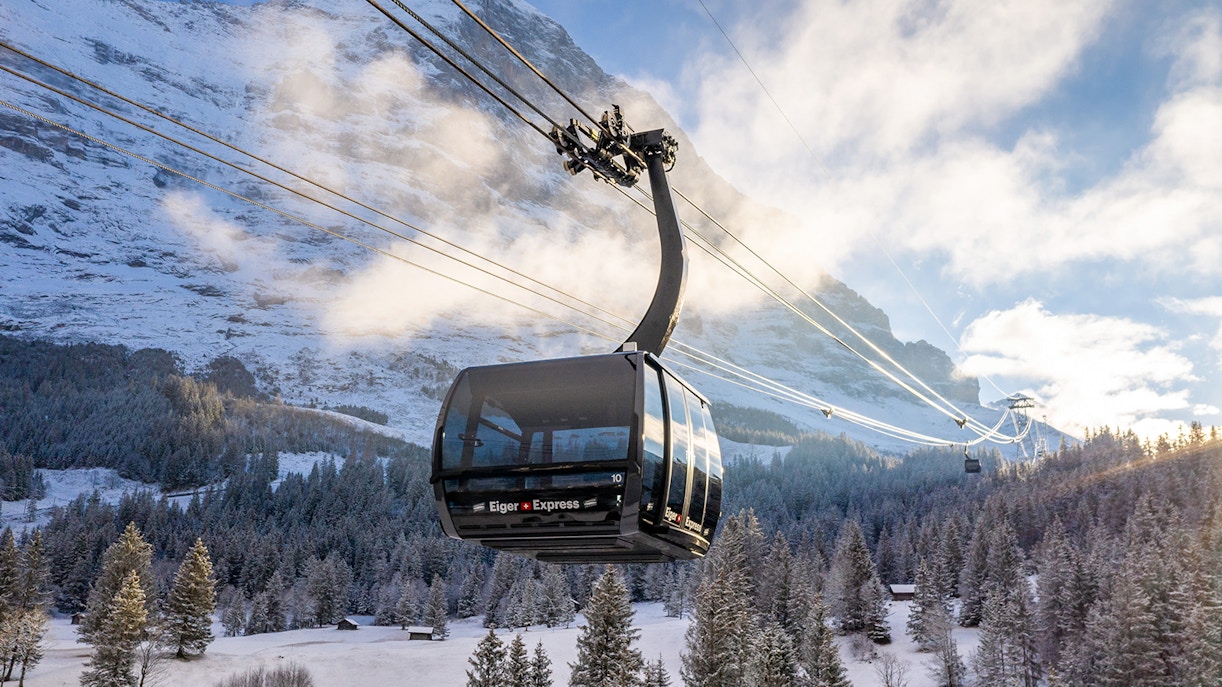 Eiger Express cable car ascending snowy mountain landscape in Switzerland.