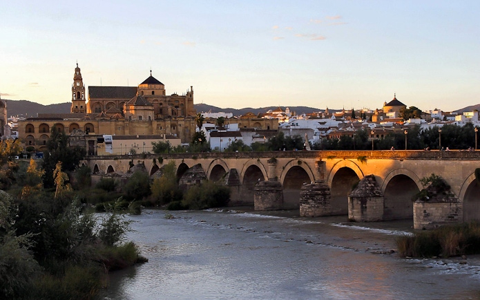 Cordoba Mosque-Cathedral and Roman Bridge at sunset, view from the river.