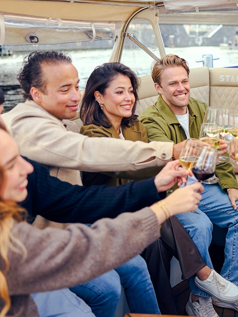Guests toasting with wine on an evening candlelight cruise.