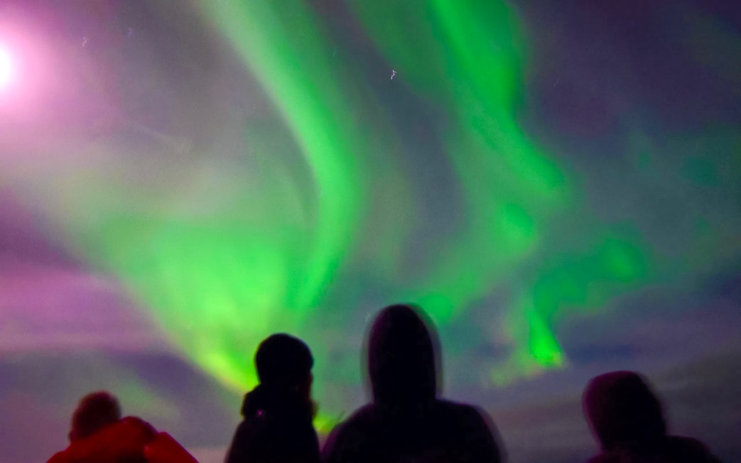 Guests viewing northern lights from a cruise ship deck.