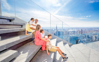 Family enjoying skyline view from Edge observation deck in New York City.