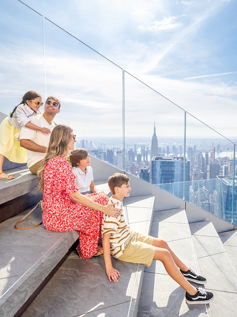 Family enjoying skyline view from Edge observation deck in New York City.