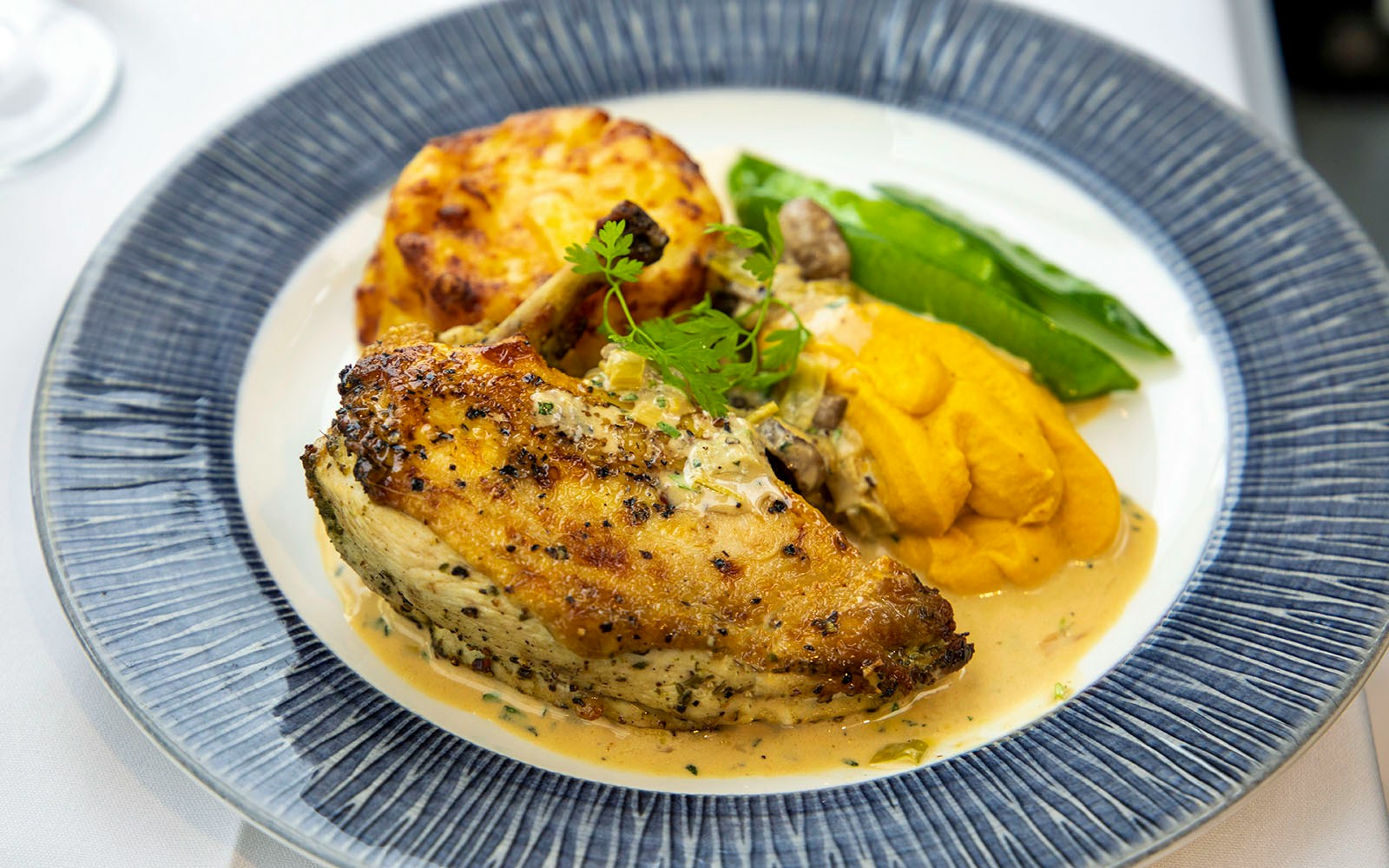 Grilled chicken with sauce, mashed carrots, and vegetables on the London Dinner Cruise.