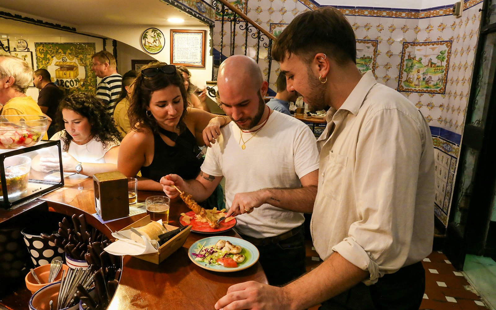 Participants trying tapas and drinks on a guided tour of Triana