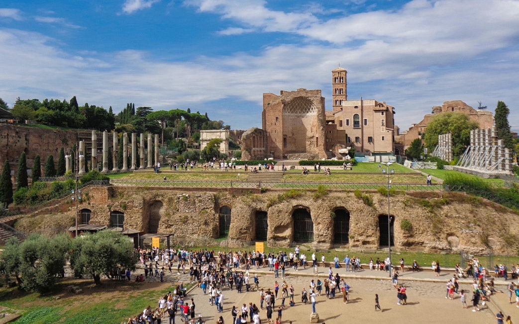 Crowds exploring ancient ruins and catacombs in Rome on a guided tour.