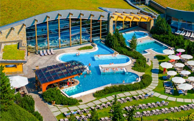 Thermal pools at Terma Bania in Białka Tatrzańska, surrounded by greenery and lounge chairs.