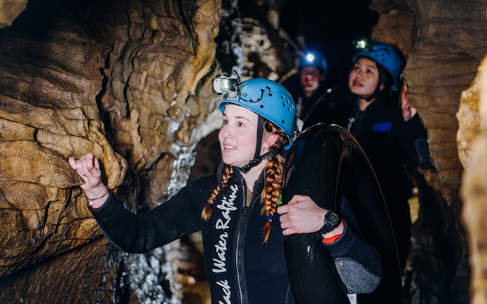 Participants exploring cave during Black Water Rafting in Waitomo.