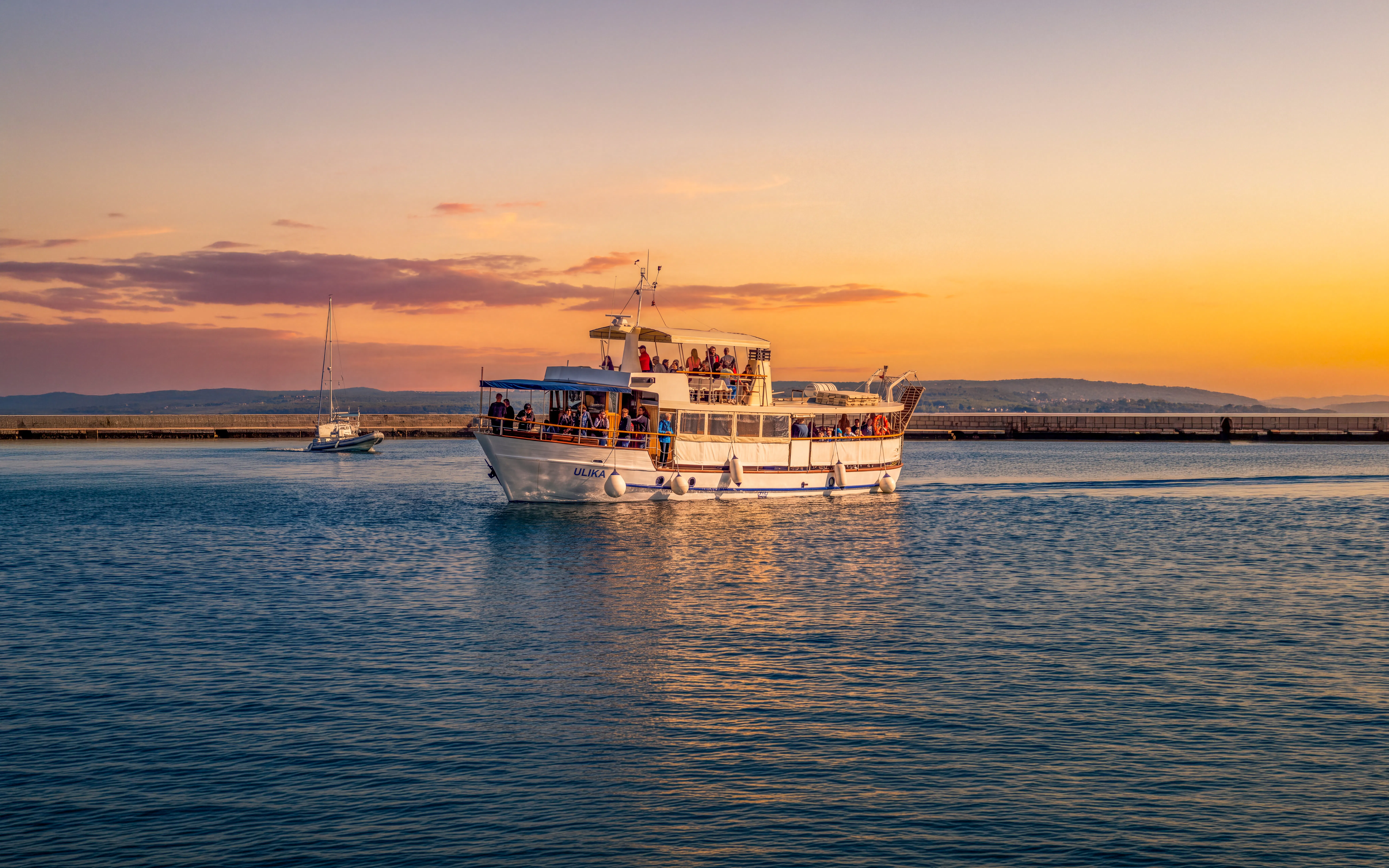 Boat tour at sunset near Brijuni National Park, Pula, with passengers on deck.