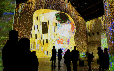 Visitors viewing Klimt's "The Kiss" projection at Fabrique des Lumières exhibition.