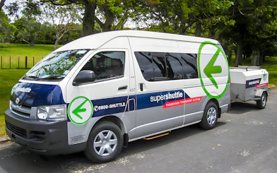 Super Shuttle van parked in a green park setting for airport transfers.