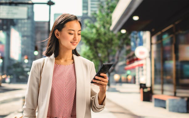 Person using smartphone on a city street in Japan, highlighting 4G eSIM connectivity.