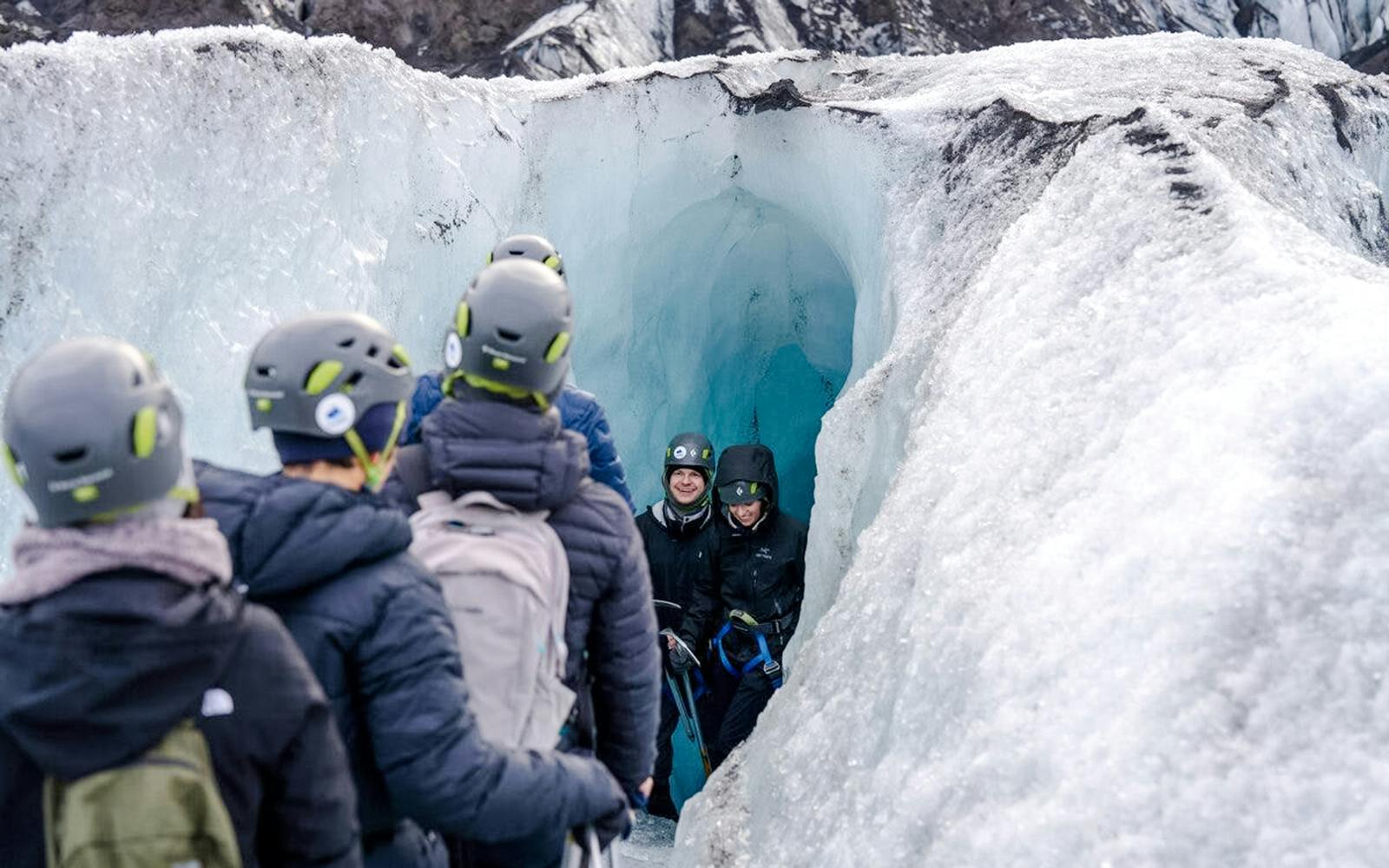 Guests exploring an ice cave on Sólheimajökull glacier in Iceland.