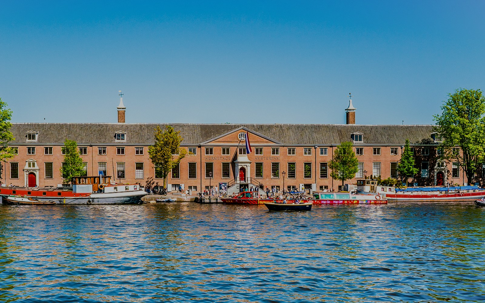H'ART Museum Amsterdam with boats on the canal in front.