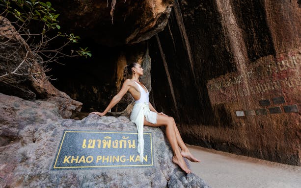 Thai visitors exploring a scenic trail in a national park, highlighting local entry fees.
