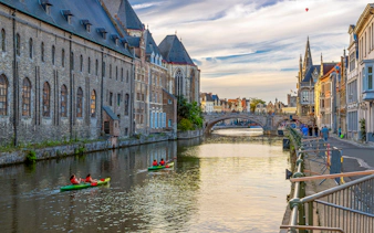 Kayakers on the Leie River in medieval Ghent, Belgium, at twilight.
