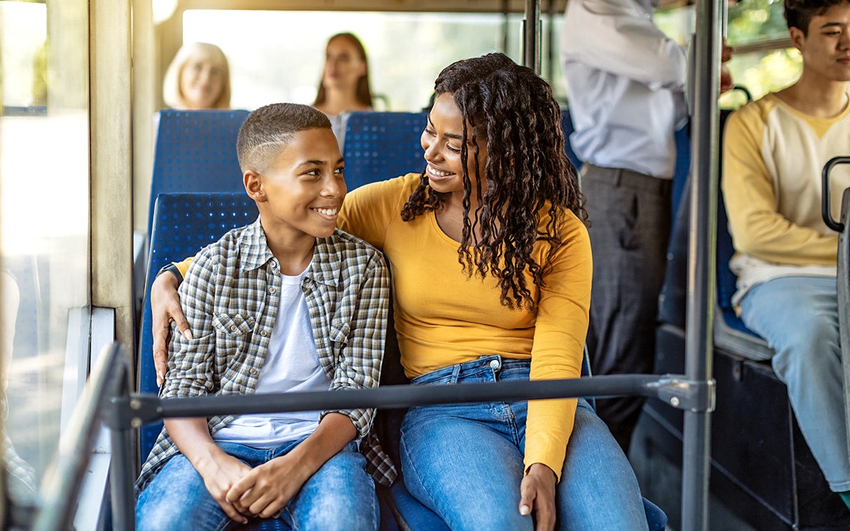 Guests smiling inside an air-conditioned bus during transfers.
