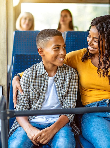 Guests smiling inside an air-conditioned bus during transfers.
