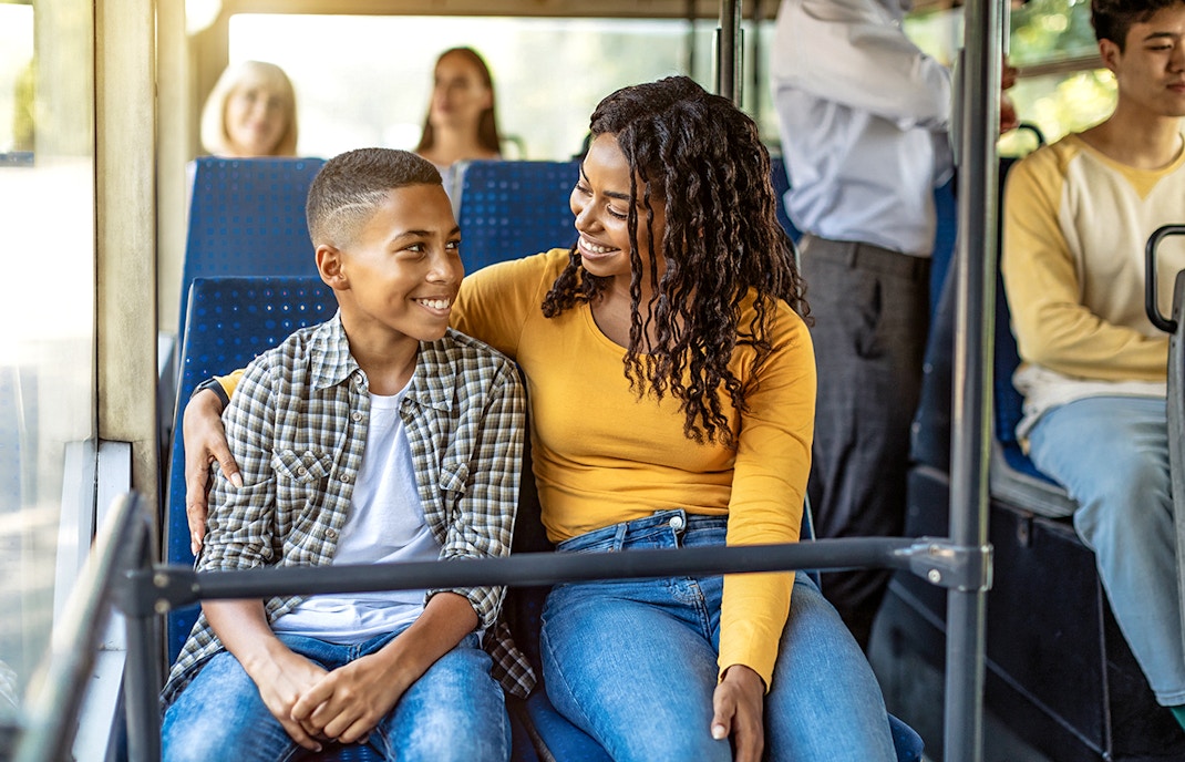 Guests smiling inside an air-conditioned bus during transfers.