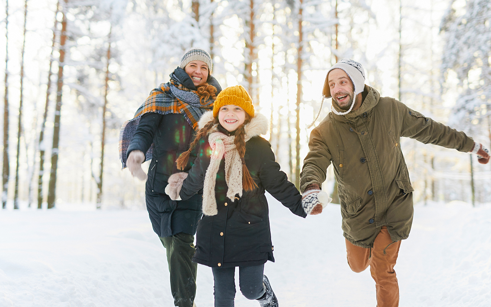 Family hiking near snow-covered Niagara Falls in winter.
