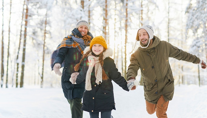 Family hiking near snow-covered Niagara Falls in winter.