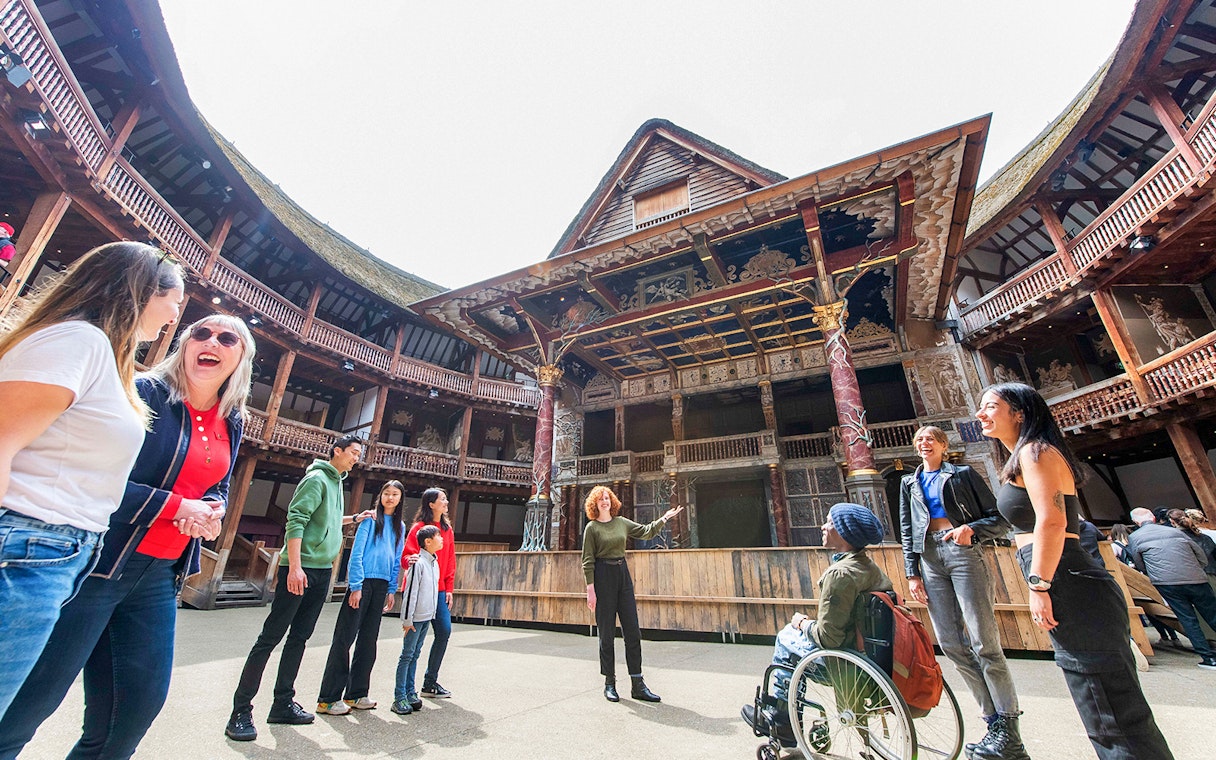 Visitors enjoying a guided tour at Shakespeare's Globe Theatre in London.