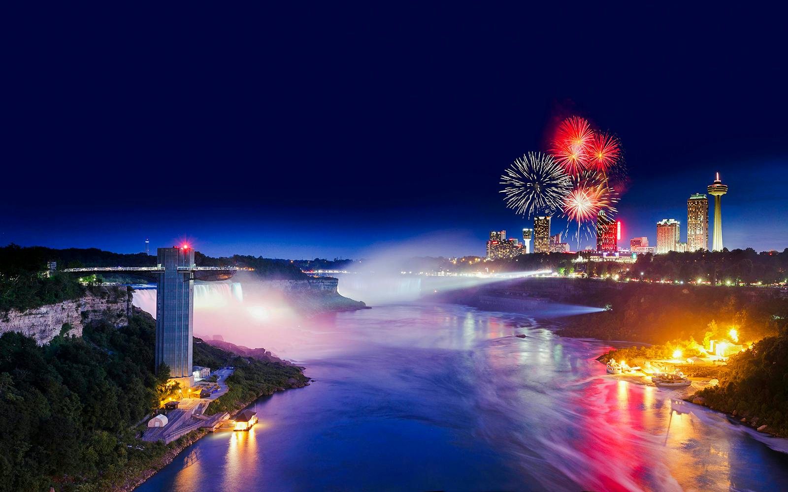 Niagara Falls evening view with fireworks and illuminated skyline, USA tour.