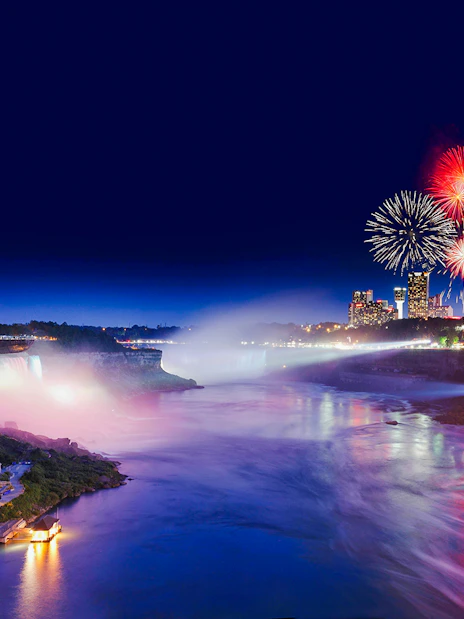 Niagara Falls evening view with fireworks and illuminated skyline, USA tour.
