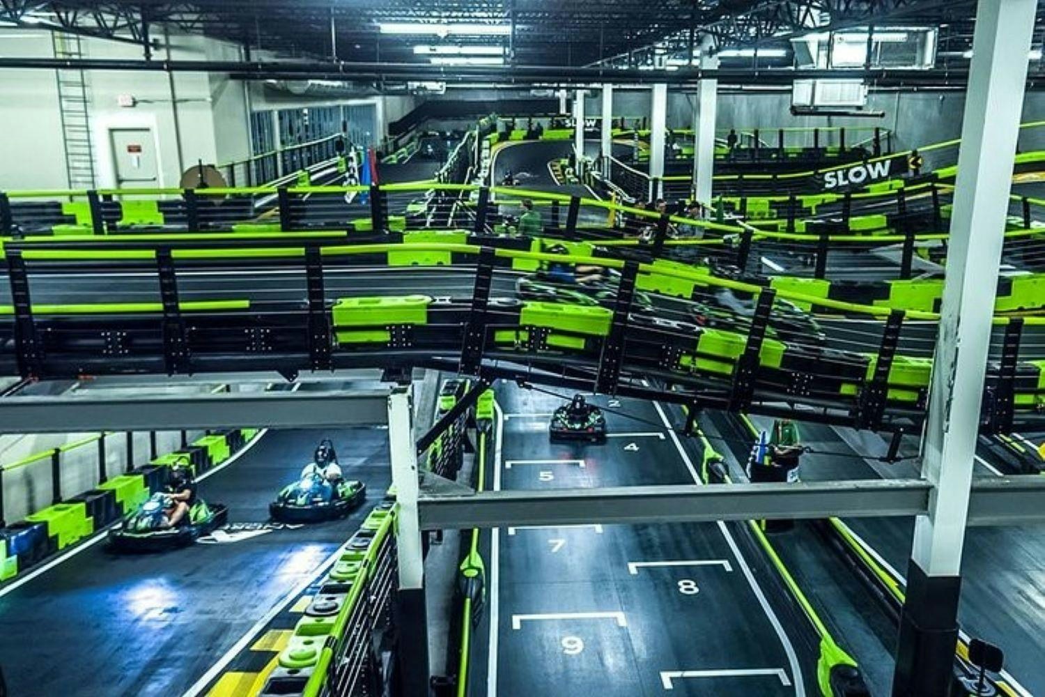 Indoor go-kart track at Andretti Indoor Karting, Orlando, with racers navigating the course.