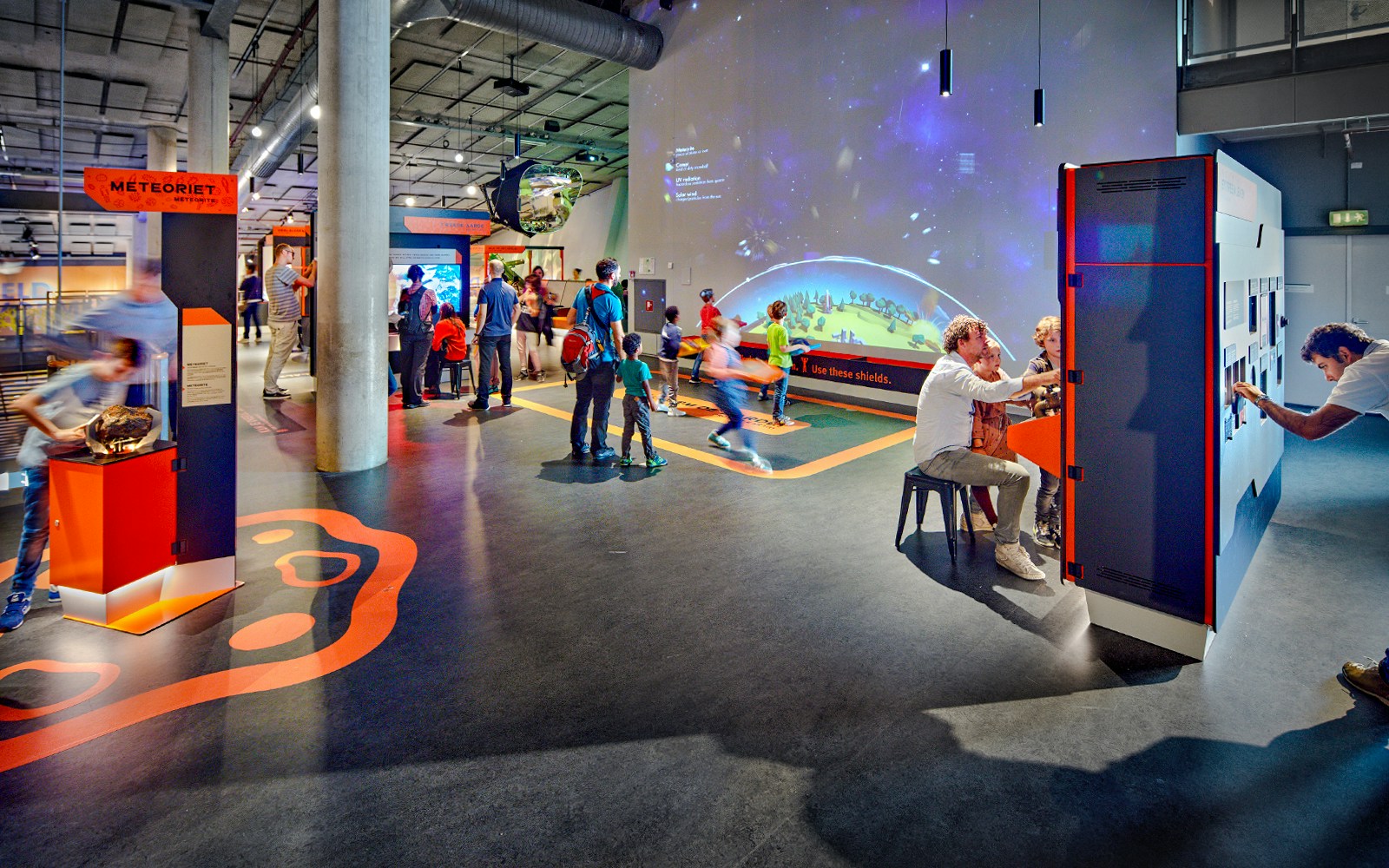 Interactive exhibits at NEMO Science Museum with visitors engaging in activities.