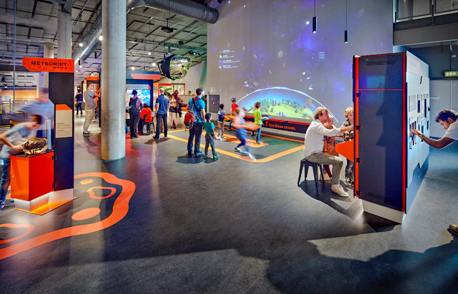 Interactive exhibits at NEMO Science Museum with visitors engaging in activities.