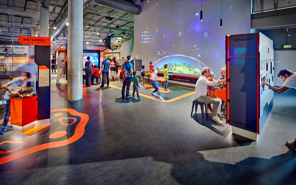 Interactive exhibits at NEMO Science Museum with visitors engaging in activities.