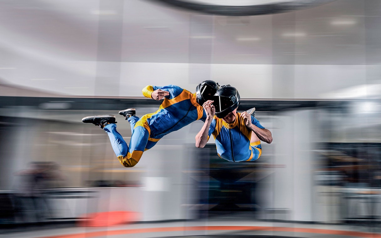 Indoor skydiving experience in Dubai with two people in flight suits.
